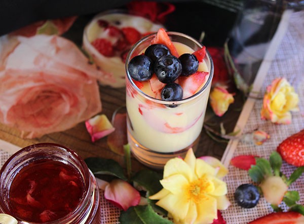 Deliciosa crema inglesa con rosas y frutos del bosque