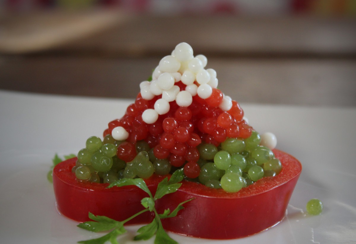 Emplatado final de la ensalada Shopska con perlas tipo caviar en aro de pimiento rojo