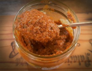 Recipiente con una salmorreta casera de color rojizo intenso, la base del sabor para un arroz socarrat.